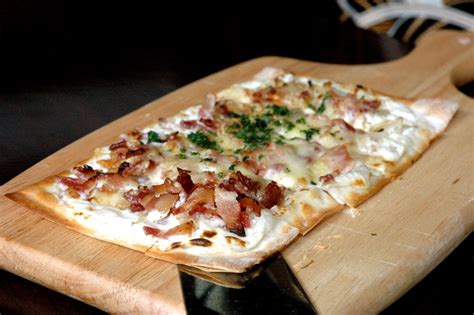 Tarte flambée: Una deliziosa combinazione di pasta sfoglia croccante e topping cremosi che fonderanno in bocca!